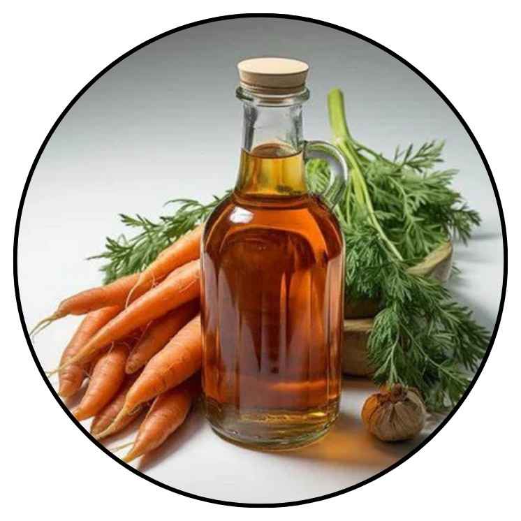 Dropper with carrot seed oil beside fresh carrots and seeds, known for its skin-rejuvenating properties.